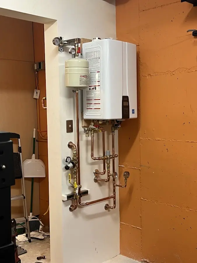 Plumbing technician inspecting water heater connections in Batesville